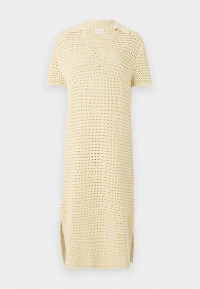 Aukštos kokybės trumparankovė megzta suknelė švelniai geltonos spalvos su V formos iškirpte ir apykakle; pasižymi tekstūruotu, atviru audiniu ir šoniniais plyšiais.