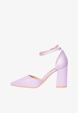 Scarpa con tacco alto color lavanda, punta appuntita, tacco a blocco e cinturino alla caviglia con fibbia su sfondo bianco.