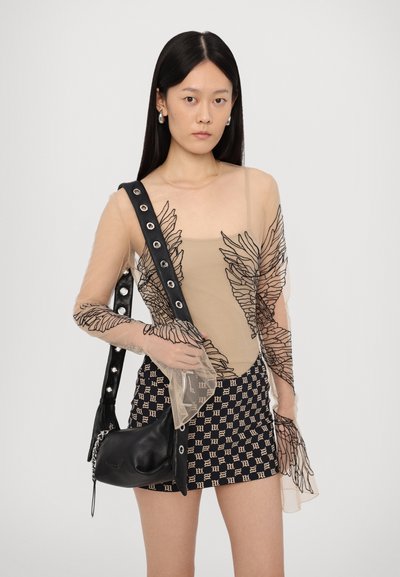 Body nudo con ricami floreali neri, abbinato a una mini gonna a fantasia. Borsa nera con dettagli argentati e una tracolla con borchie oversize.