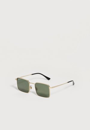 Vierkante groen getinte glazen met dunne gouden metalen monturen en zwarte pootjes van een zonnebril op een witte achtergrond.