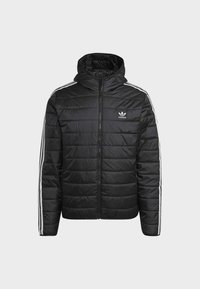 Černá prošívaná bunda se zipem, kapucí a třemi bílými pruhy na každém rukávu. Na levé hrudi se nachází logo Adidas.