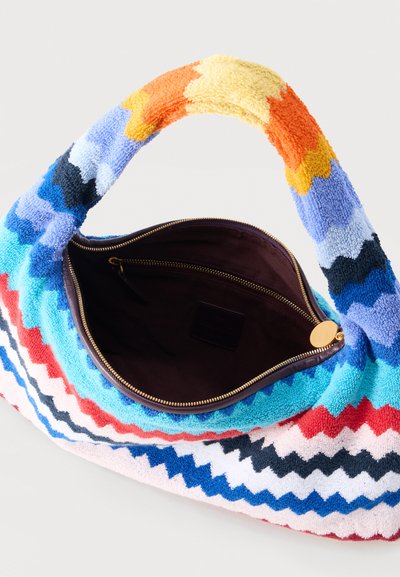 Υφασμάτινη τσάντα με πολύχρωμο μοτίβο ζιγκ ζαγκ, ανοιχτό φερμουάρ στην κορυφή που αποκαλύπτει σκοτεινό εσωτερικό και επενδεδυμένη, πολύχρωμη λαβή.