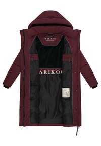 Lungo cappotto bordeaux con zip frontale, cappuccio e fodera interna nera. Include dettagli con il marchio e due tasche con zip all'interno.