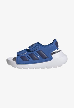 Sandálias azuis com correias ajustáveis, feitas de material flexível. Sola em borracha branca com detalhes texturizados. Design aberto e construção leve.