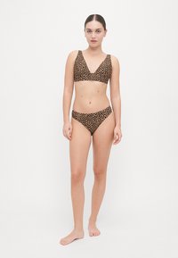 Leopard print bikini set featuring a V-neck top with wide straps and matching low-rise bottoms. Fabric has a soft texture.