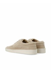 Zapatillas de ante beige con un diseño de corte bajo, suela de goma blanca y detalles de costura mínimos a lo largo de los lados y alrededor de los ojales.