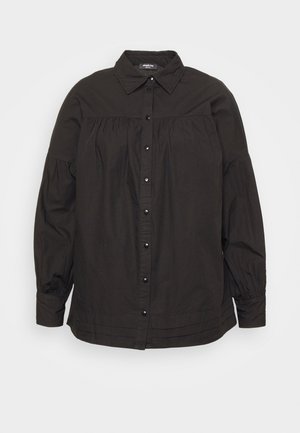 Camisa preta de algodão com colarinho clássico, ajustada na yoke, com detalhe plissado e mangas elásticas. Apresenta fechamento frontal com botões.