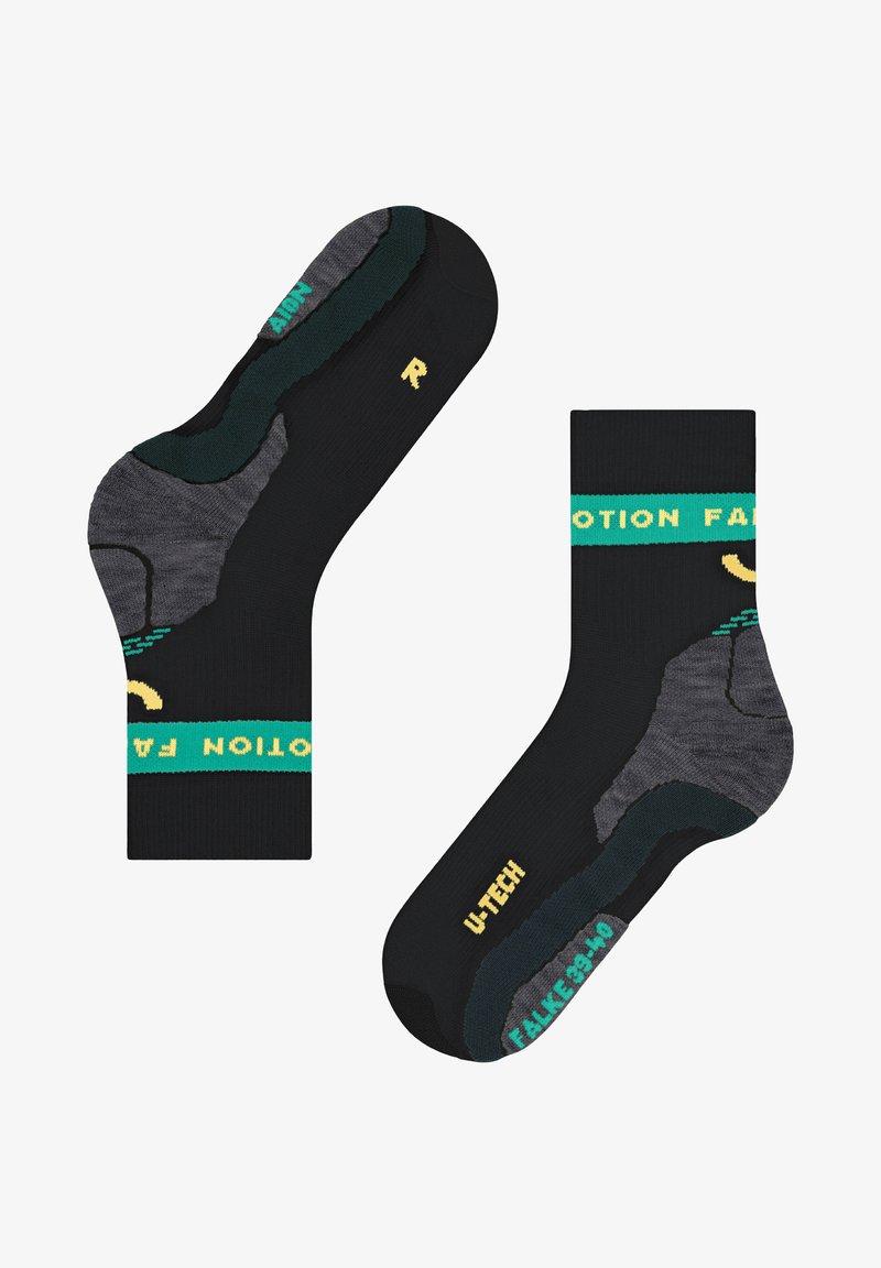 Chaussettes noires avec des accents verts et jaunes. Zones de talon et d'orteil renforcées, dotées d'un design texturé noir et gris. Nom de la marque affiché.