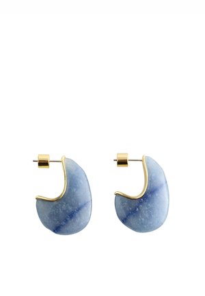 Paire de boucles d’oreilles créoles en pierre bleue polie avec des accents en métal doré et des attaches dorées pour oreilles percées.