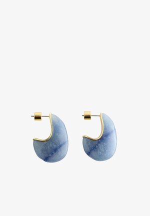 Paire de boucles d’oreilles créoles en pierre bleue polie avec des accents en métal doré et des attaches dorées pour oreilles percées.