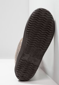 Semelle de chaussure en caoutchouc avec un motif zigzag texturé. Matériau noir avec un bord renforcé. Indicateur de taille numérique "31" au fond.