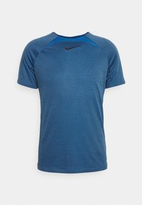 Camiseta deportiva azul de manga corta, con cuello redondo y tejido texturizado. Logo de Nike en negro en la parte delantera, acentuado con inserciones azules en los hombros.