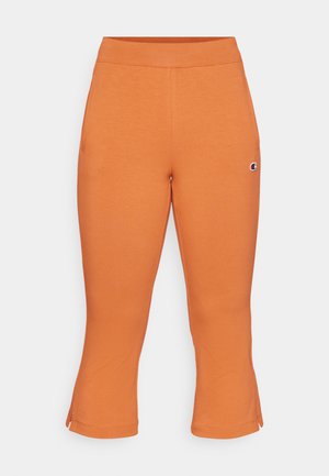 Oranžinės medvilnės mišinio capri kelnės su elastine juosta ir išplėstais apačiais. Kairėje šlaunies pusėje yra mažas logotipas.