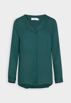 Groene blouse met lange mouwen en een V-hals, gemaakt van zachte stof, met een licht gebogen zoom en een enkele plooi in het midden van de voorkant.