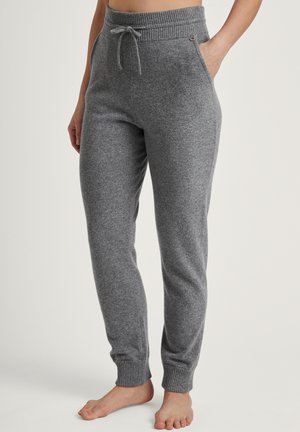 Graue, dehnbare Jogginghosen aus weichem Stoff. Mit einem gerippten Bund, Kordelzugverschluss und seitlichen Taschen. An den Knöcheln gerippt.
