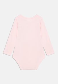 Βρεφικό κορμάκι με μακριά μανίκια σε απαλό ροζ βαμβάκι, με λαιμόκοψη στρογγυλή και κλείσιμο με κουμπάκια στο κάτω μέρος. Ομαλή υφή, απλός σχεδιασμός.