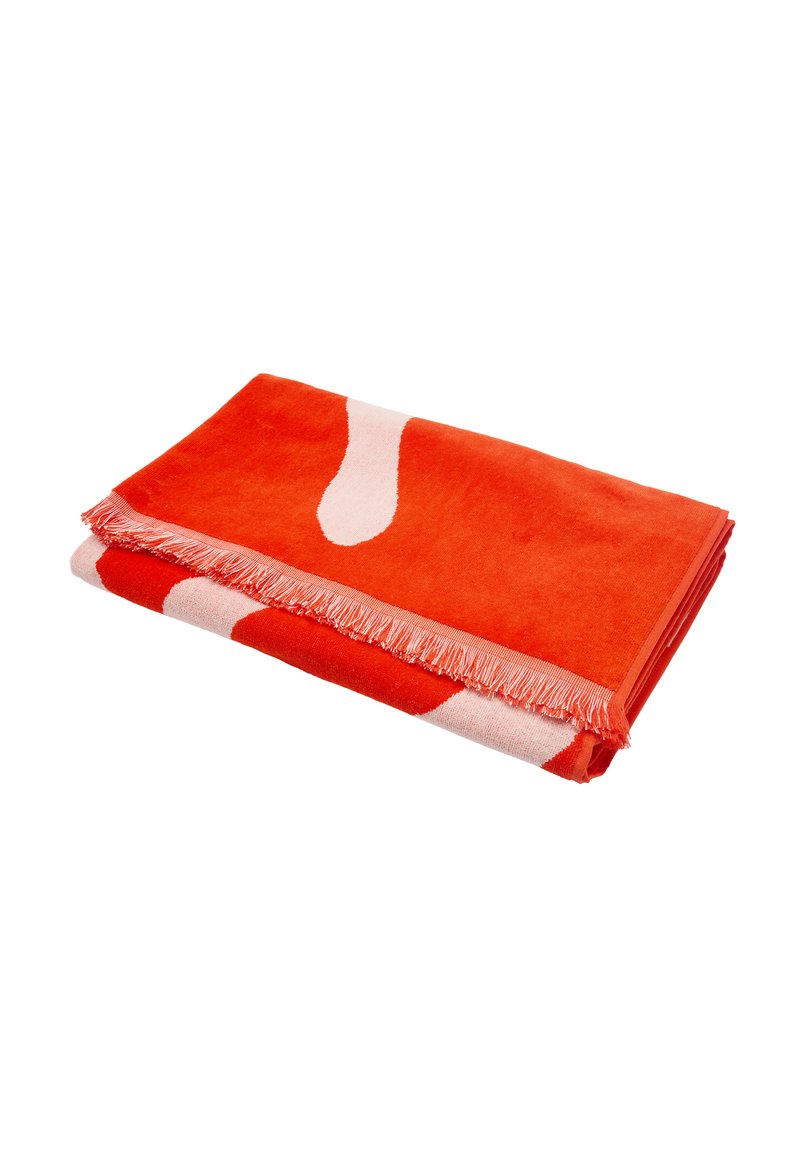 Pomarańczowy i kremowy wzorzysty koc, z frędzlami na brzegach, miękką teksturą i abstrakcyjnym wzorem zawierającym duży motyw plamy.