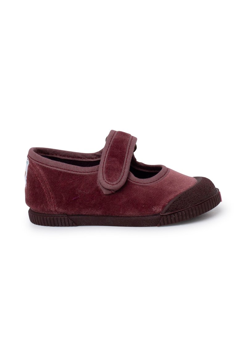 Scarpa Mary Jane in velluto bordeaux con cinturino in velcro. Caratterizzata da una punta arrotondata e suola in gomma con scanalature per la trazione. Texture morbida.