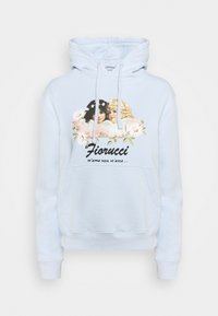 Vaaleansininen huppari, jossa on graafinen kuvasto kahdesta enkelistä kukkien ympäröimänä. Suunnittelussa on teksti "Fiorucci" ja "m'ama non m'ama..."