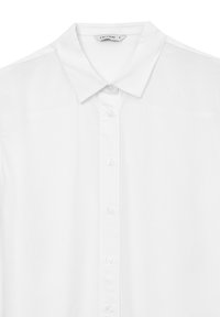 Camicia bianca con colletto a punta e etichetta di piccole dimensioni all'interno del colletto che riporta "Calliope S."