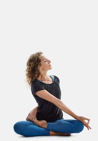 Black athletic top with a scoop neckline, paired with blue yoga leggings. The figure is seated in a yoga pose with curled hair.