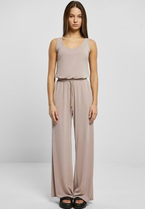 Mono sin mangas beige con parte superior ajustada y pantalones de pierna ancha, hecho de una tela suave y lisa. Presenta una cinturilla elástica y un cordón de ajuste.