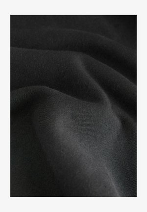 Black fabric with a smooth texture, displaying gentle folds and a soft, slightly fuzzy surface. Uniform color with no patterns.