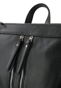 Sac à main en cuir noir avec une surface texturée, deux tirettes de fermeture éclair et une poignée supérieure. Les coutures sont visibles le long des bords.