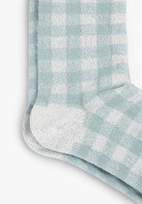 Calcetines a cuadros en verde menta y blanco con una tela suave y texturizada. Diseño con vuelta y áreas de puntera y talón reforzadas.