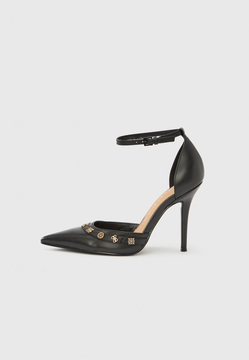 Μαύρο δερμάτινο γοβάκι με ψηλό τακούνι, μυτερή μύτη, λουράκι στον αστράγαλο και διακοσμητικά σε χρυσό τόνο στη φάσα. Λείο υλικό.