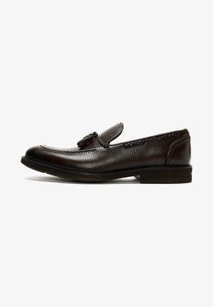Mocassin à glands en cuir texturé marron foncé avec semelle noire et bout arrondi, présenté en profil latéral sur fond blanc.