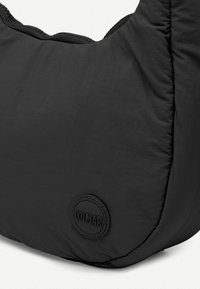 Fekete puffertáska texturált felülettel és kör alakú, dombornyomott Colmar logóval. Ívelt sziluettel és megerősített varrással rendelkezik.