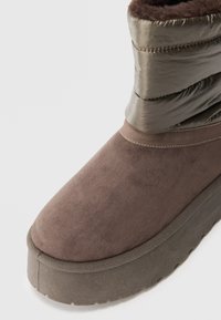 Brune semsket og nylon vinterstøvel med tykk platåsåle og polstret øvre kant for kaldt vær.