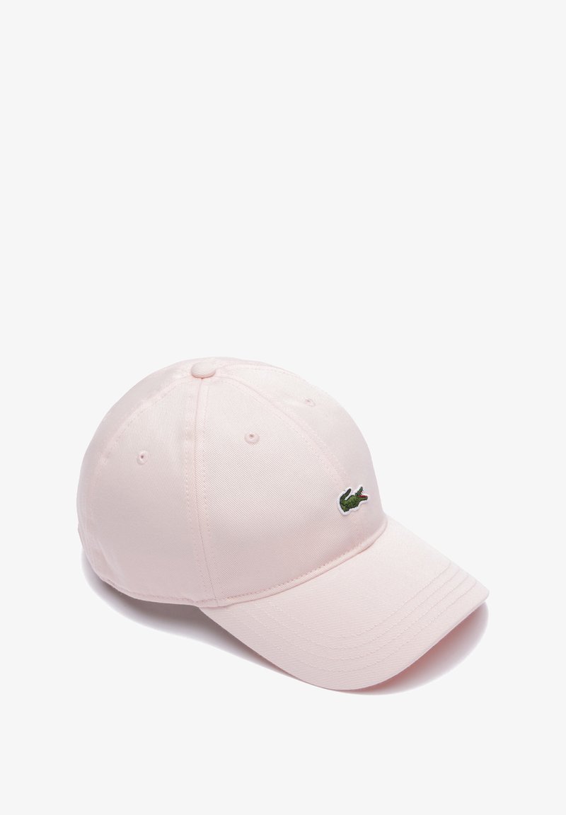 Gorra de algodón rosa con visera curvada y logo de cocodrilo verde bordado en la parte frontal. Cuenta con ojales de ventilación y costuras a tono.