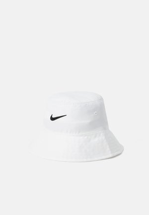 Bela klobuk iz platna z črnim Nike logotipom spredaj. Mehak material s širokim robom, ki se nagiba navzdol.