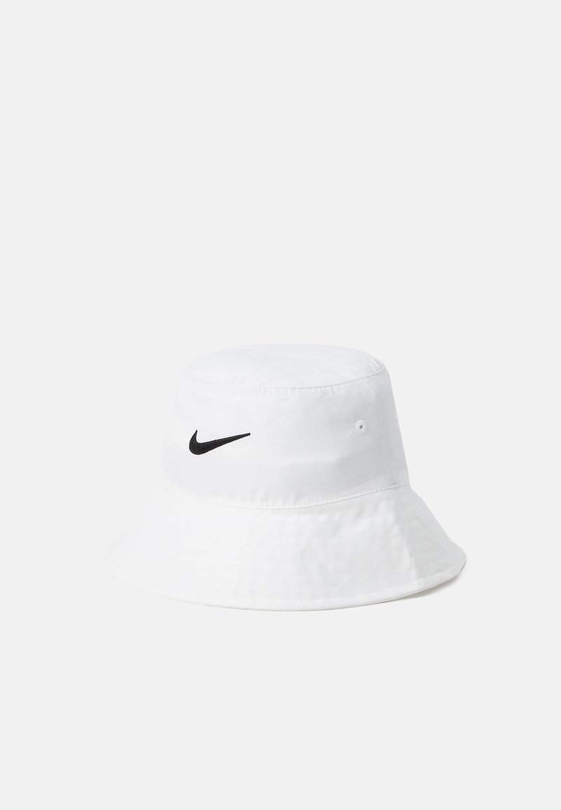 Baltas medvilninis skrybėlė, su juodu Nike logotipu priekyje. Minkšta tekstūra, su plačiu, žemyn besileidžiančiu kraštu.