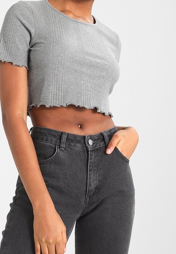 Šedý žebrovaný crop top s obloukovým lemem, který je spárován s černými džíny s vysokým pasem, které mají knoflíkové zapínání a přední kapsy.