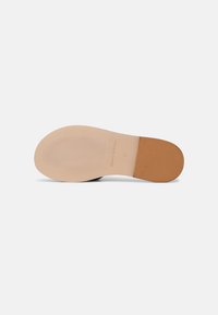 Semelle de chaussure de couleur claire avec une surface texturée et un accent marron au talon. Présente le nom de la marque "Marc O’Polo" et la taille "37" en relief.