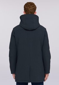 Abrigo con capucha de color azul marino oscuro y textura suave, con un corte relajado, detalles de costura y un dobladillo trasero más largo, adecuado para el uso casual.
