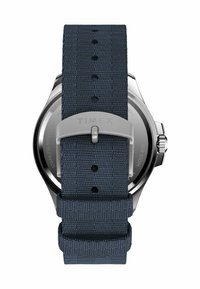 Blauer gewebter Uhrenarmband mit silberner Timex-Schnalle, befestigt an einem Uhrengehäuse aus Edelstahl mit Wasserbeständigkeitsmarkierungen.