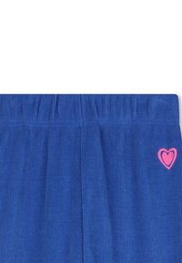 Blauwe ribfluwelen broek met een elastische tailleband heeft een klein roze hartlogo aan de linkerkant.