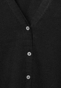 Svart cardigan med V-ringning, fem runda grå knappar och en mjuk stickad textur. Enkelt och mångsidigt för lager-på-lager.