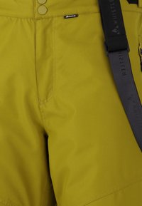 Geelgroene shorts van duurzame stof, met een platte tailleband, knoopsluitingen en een zwarte verstelbare riem met branding.