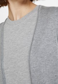Grå bomull t-shirt med rund hals, korta ärmar och en slät yta. Sömnadsdetaljer ger subtilt designintresse.