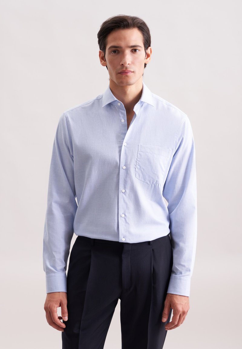 Camicia a maniche lunghe blu chiaro realizzata in tessuto intrecciato, con chiusura frontale a bottoni, colletto a punta e tasca applicata sul lato sinistro del petto.