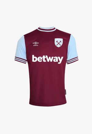 Camiseta de fútbol de color granate y azul celeste con mangas cortas. Presenta el logo "betway" en blanco y el escudo del club con martillos cruzados, con cuello a rayas.