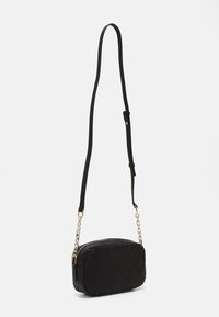 Sac à bandoulière rembourré noir avec fermeture éclaire, doté d'une chaîne et d'une bandoulière en cuir. Texture lisse avec un motif en losanges.