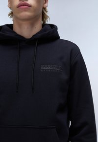 Donkerblauwe hoodie van zachte stof met een voorzak, verstelbare trekkoorden en een reliëflogo op de borst.