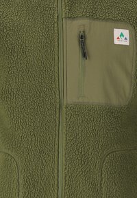 Grüner Fleece-Weste mit einer Reißverschlusstasche auf der Brust und glatten Stoffakzenten. Verfügt über eine strukturierte Oberfläche und ein Markenlabel.