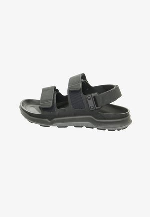 Mustat ulkosandaalit, joissa on säädettävät Velcro-nauhakiinnitykset, kumipohja, teksturoitu päällinen ja tukeva muotoilu mukavuutta ja kestävyyttä varten.